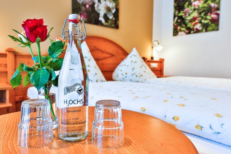 Hotelzimmer mit Tisch, Glas und Erfrischungsgetränk darauf