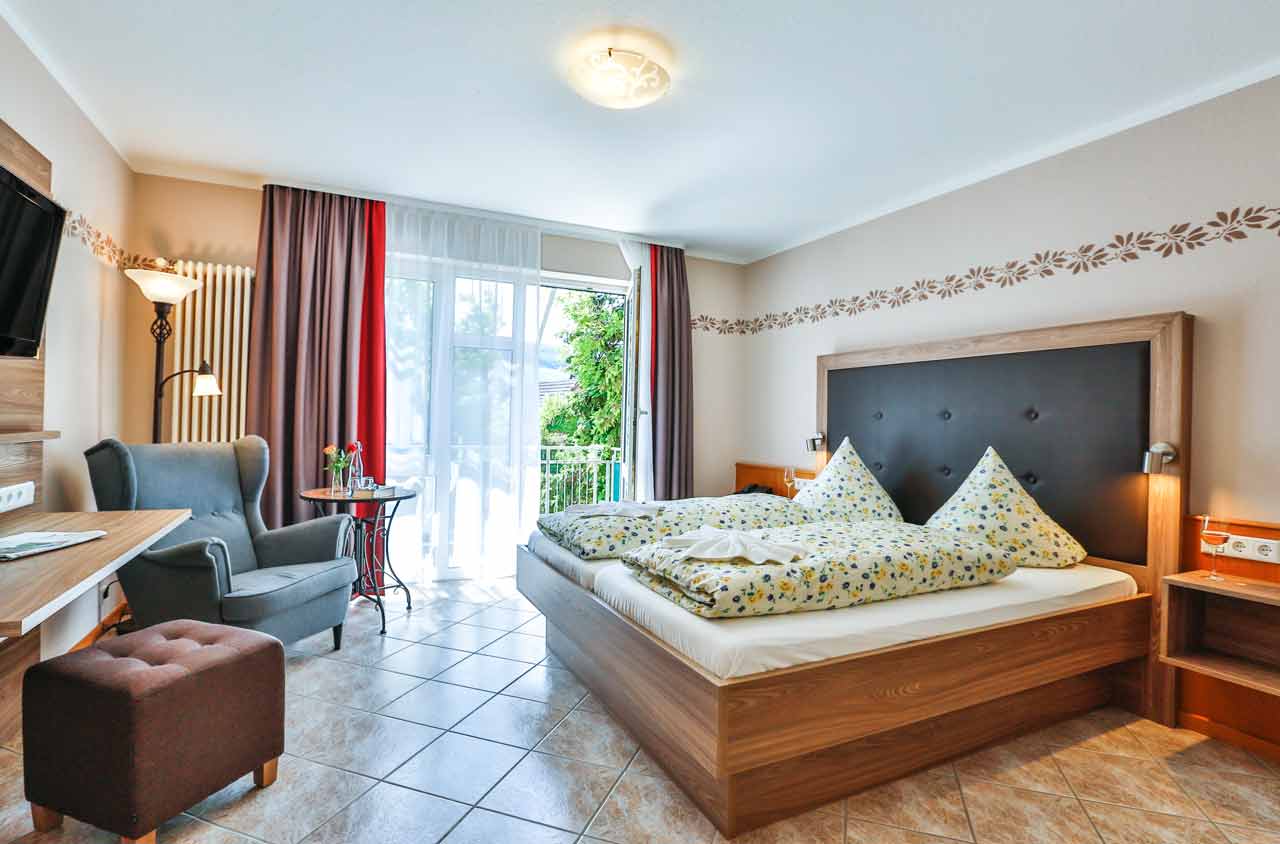 Modern eingerichtetes Schlafzimmer mit Doppelbett und Sitzbereich